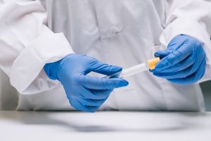 Female medical or scientific researcher holds in hands a test tube in a laboratory.